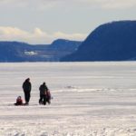 A family walking across the frozen lake in winter