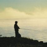A silhouette of a man fishing
