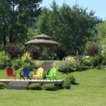 A park with colourful muskoka chairs in the foreground