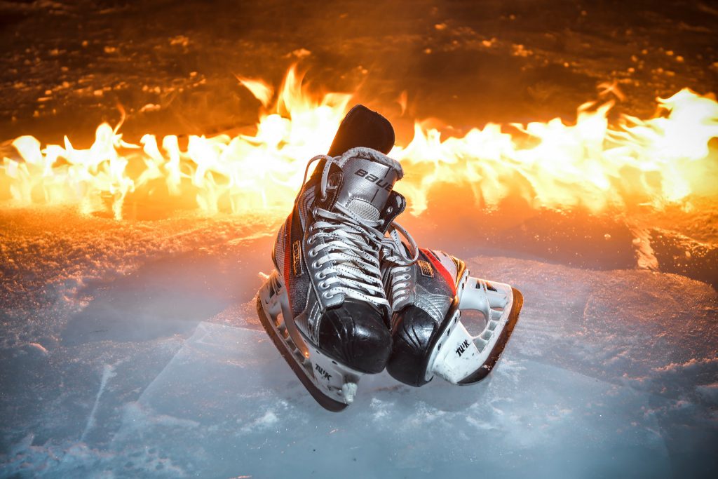 A pair of ice skates in front of a fire